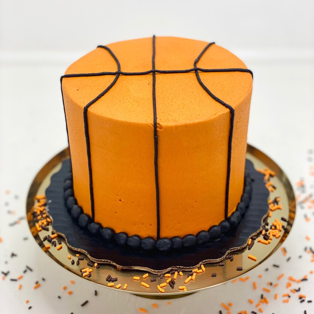 A sculpted basketball birthday cake in vibrant orange buttercream from a custom cake bakery in Indianapolis.