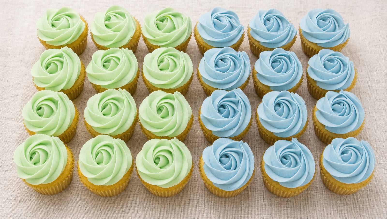 A tray of pastel blue and green rose-swirl buttercream cupcakes from Sweet Escape Cake Company, one of the best cupcake bakeries in Indianapolis.