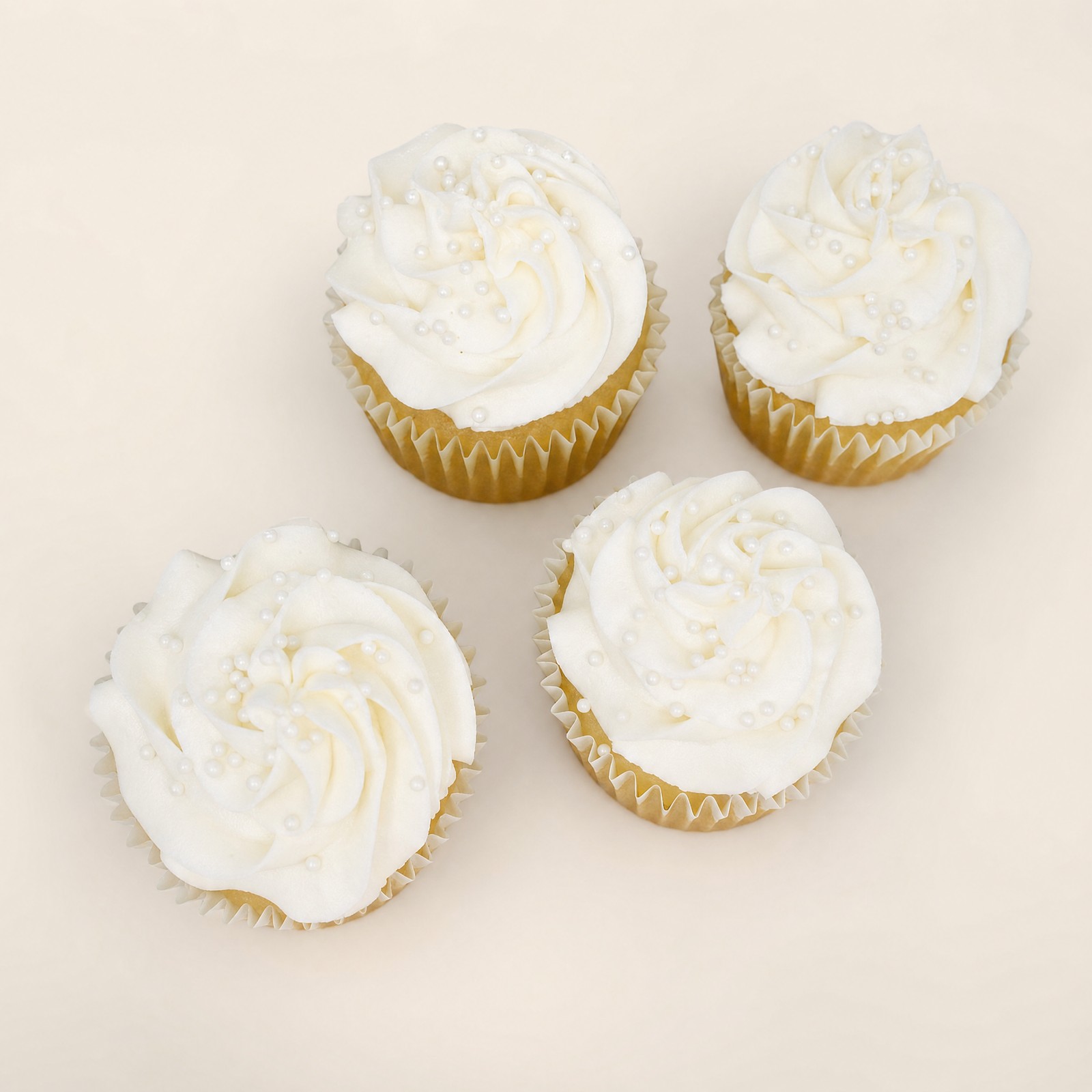 White buttercream wedding cupcakes with pearl sprinkles for a cupcake tower by Sweet Escape Cake Company.
