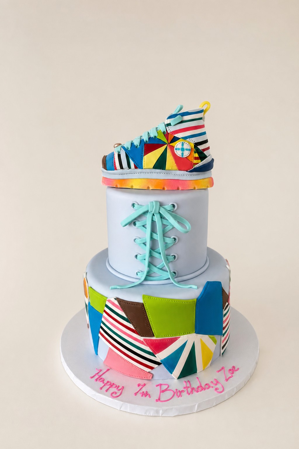 A two-tier cake with a sculpted fondant topper, the same technique used for a football birthday cake at an Indianapolis bakery.
