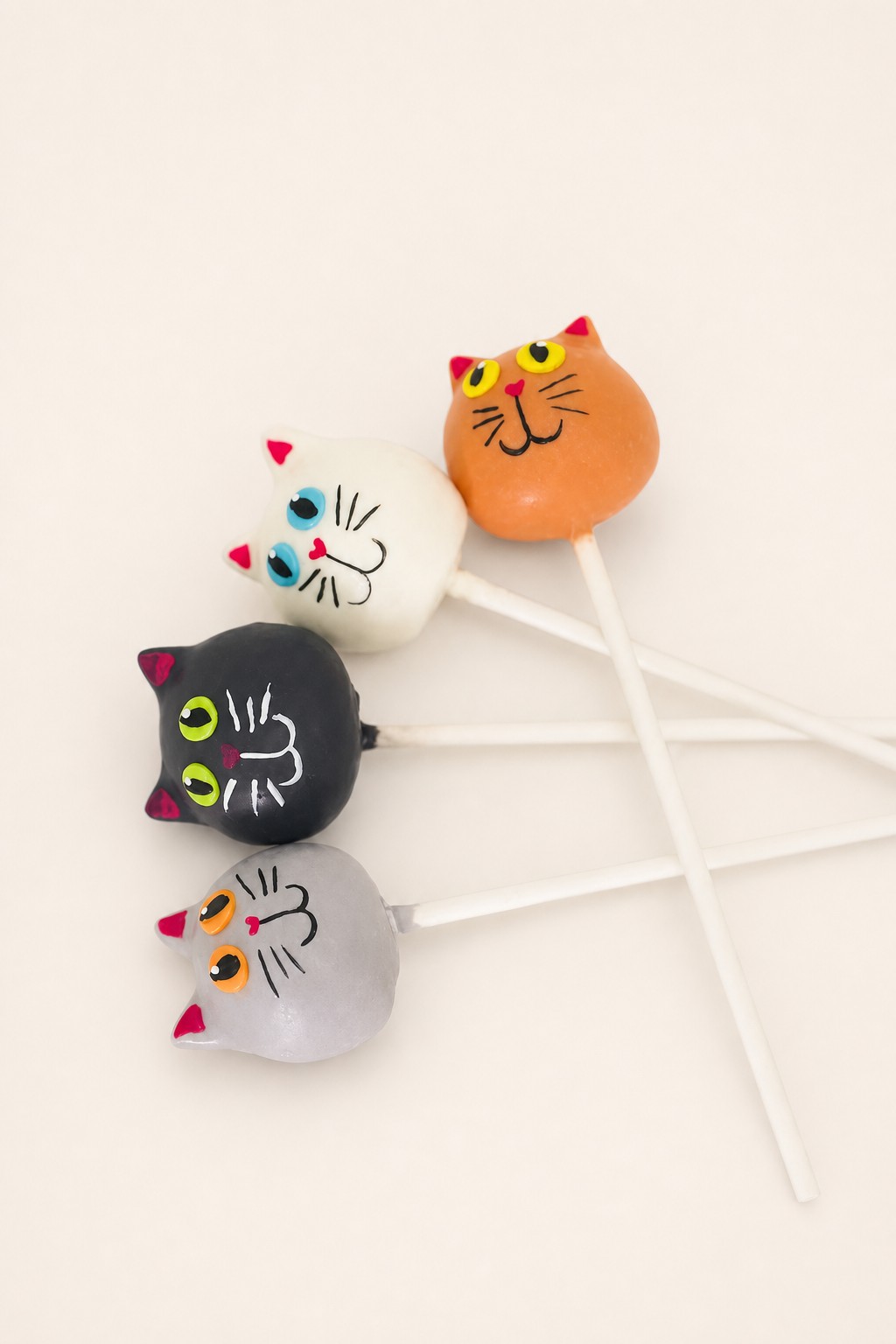 Black, orange, white and grey cat cake pops with piped faces, Halloween cake pops made by Sweet Escape Cake Company in Indianapolis.