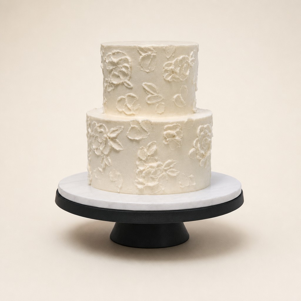 A textured buttercream cake with hand-piped cream flowers in white and ivory, a rustic wedding cake idea from Sweet Escape Cake Company.