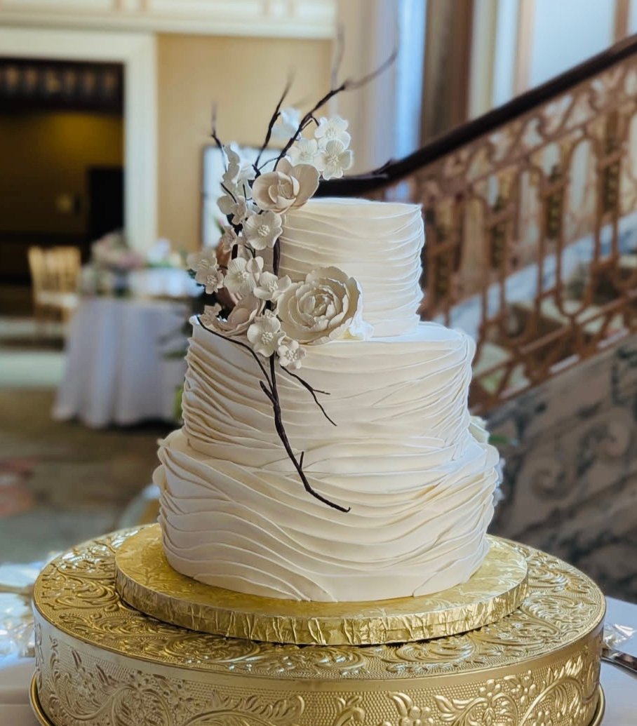 A three-tier white buttercream wedding cake with sugar flowers by Sweet Escape Cake Company in Indianapolis.