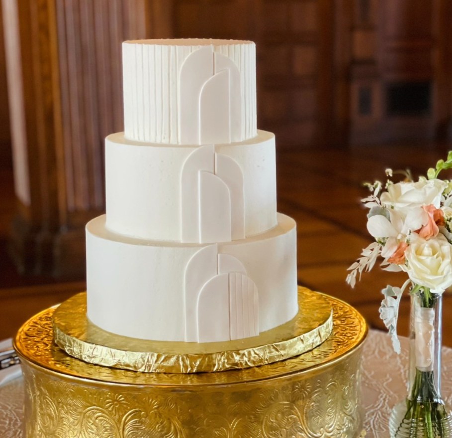 A three-tier buttercream wedding cake in Indianapolis with a smooth finish and gold accents.