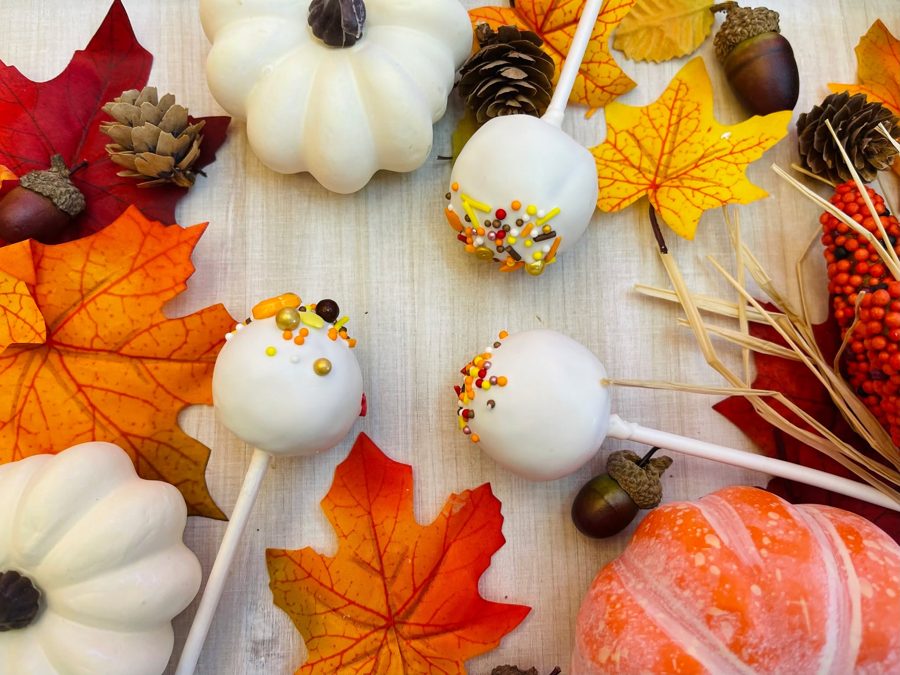 White coated cake pops decorated with festive autumn-colored sprinkles, perfect for fall holidays and celebrations.