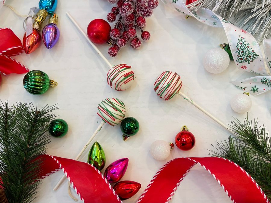 White cake pops decorated with festive red and green drizzles, perfect for a Christmas or holiday celebration.