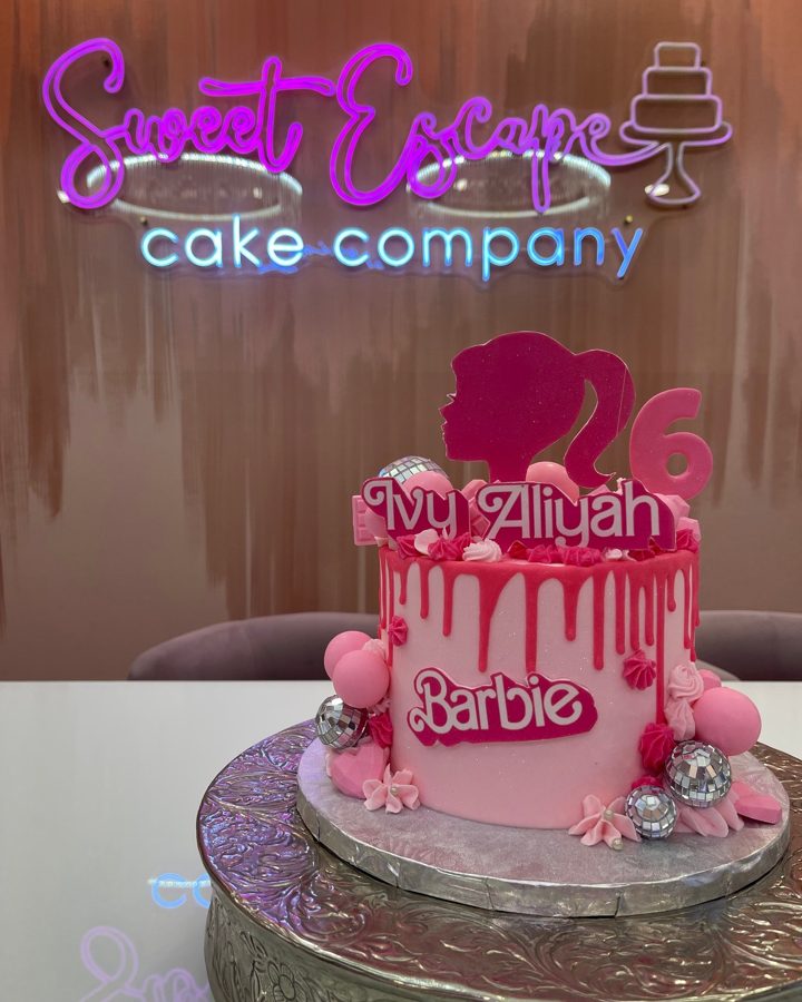 A vibrant pink Barbie-themed drip cake for a 26th birthday, featuring disco balls, pink balloons, and a personalized 'Ivy Aliyah' topper.