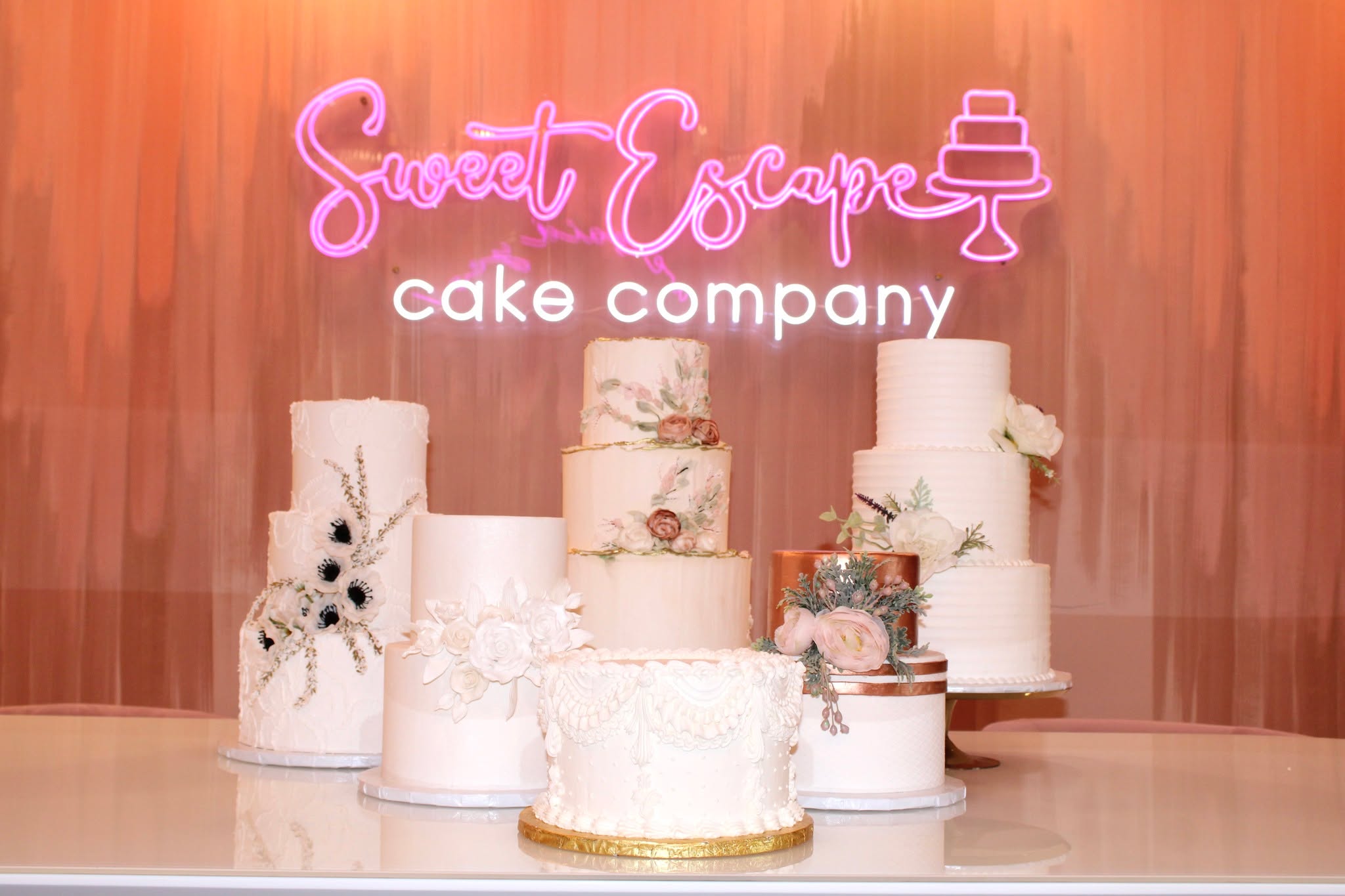 Display of multi-tier Sweet Escape wedding cakes