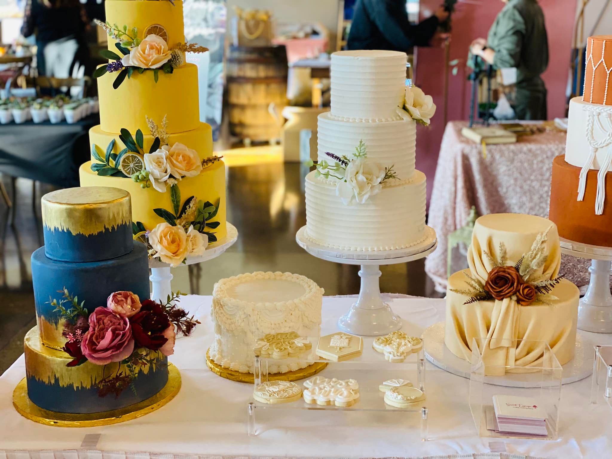 Sweet Escape wedding cakes in yellow buttercream, navy and gold, and white