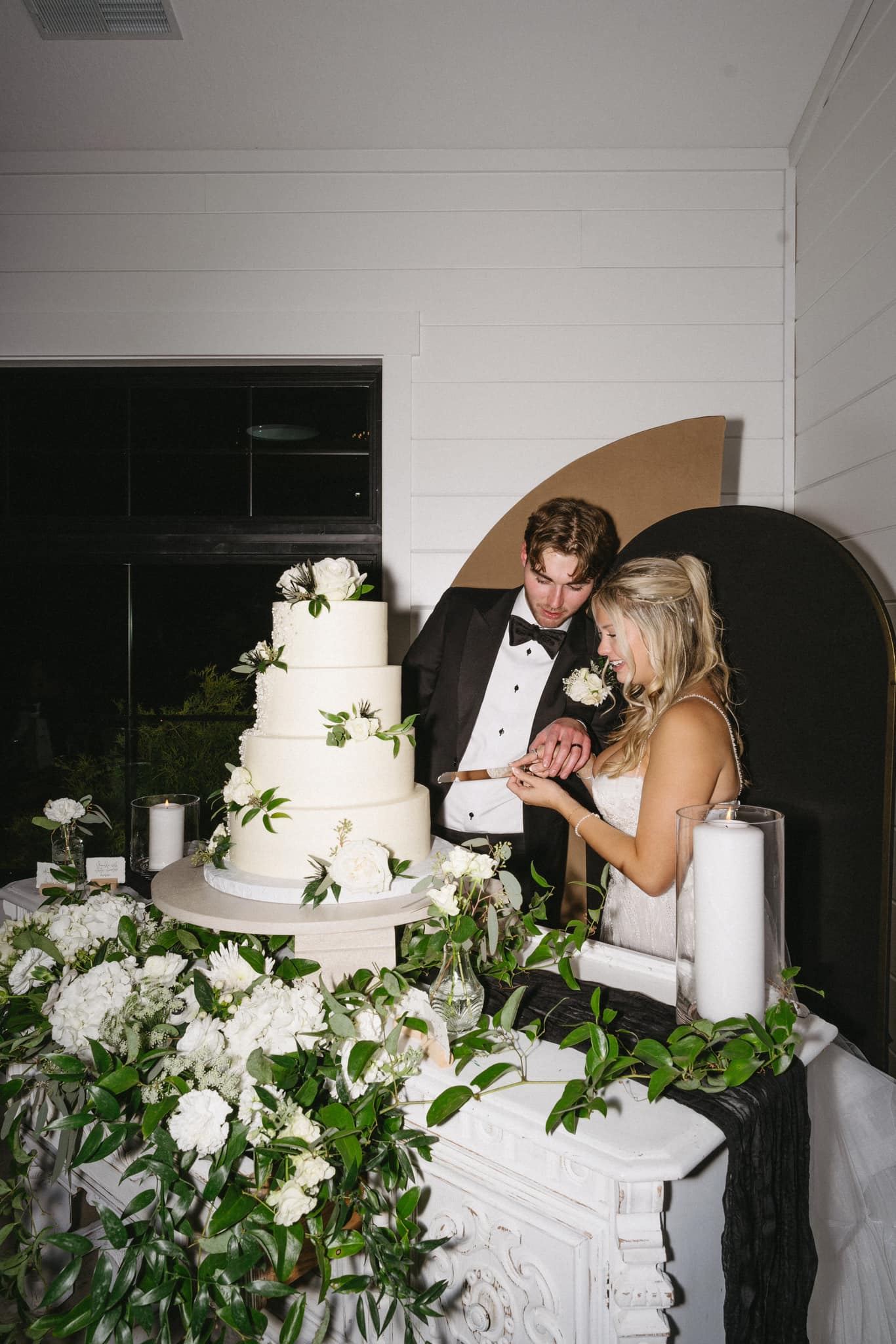 Couple cutting their elegant Sweet Escape wedding cake